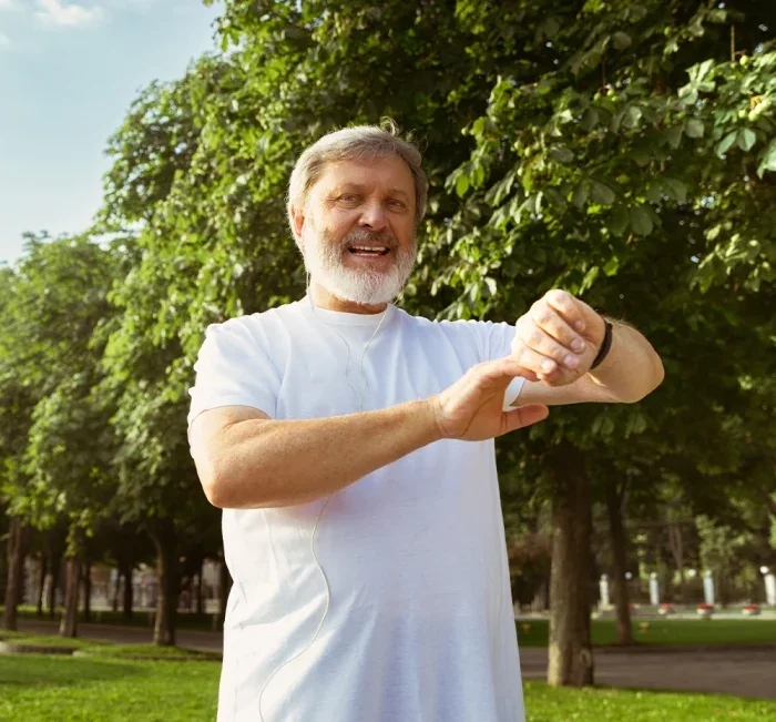 Man outdoors checking his watch, full of energy